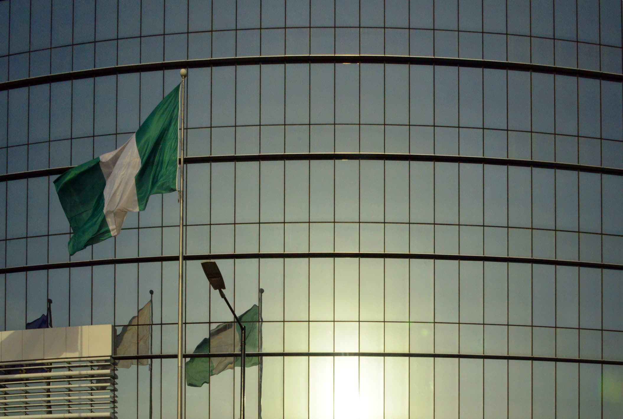 Flag of Nigeria and modern glass façade, Lagos, Nigeria